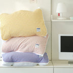 Oikos Triple Stripe pillow covers stacked in yellow pink and blue